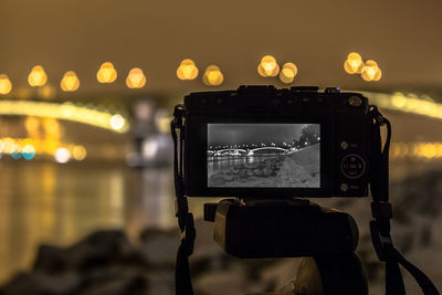 Close-up of camera at riverbank during night