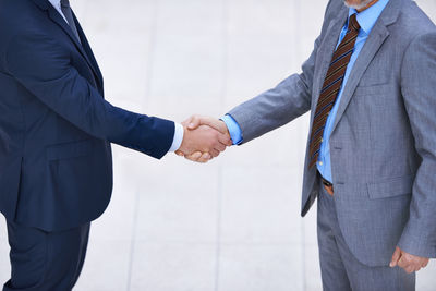 Midsection of business colleagues shaking hands