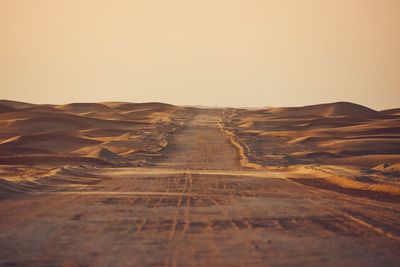 Empty desert road in the middle sand dunes. abu dhabi, united arab emirates