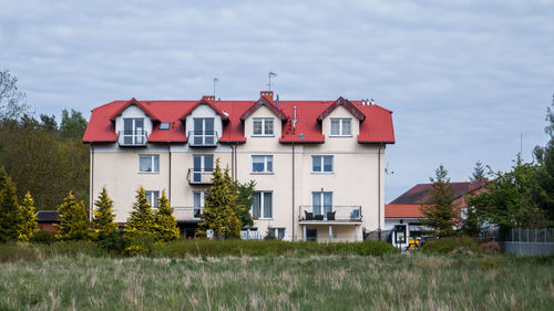 Houses by building against sky
