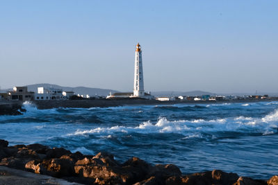 Scenic view of sea and buildings against clear sky