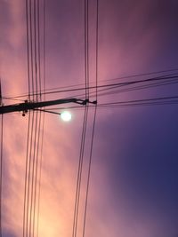 Low angle view of silhouette electricity pylon against sky during sunset