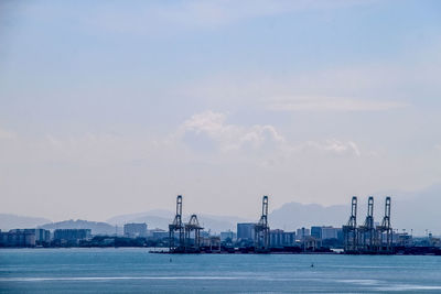 Commercial dock by sea against sky