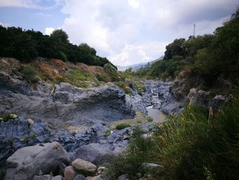 Scenic view of river amidst rocks against sky