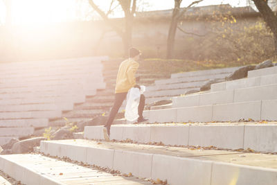 Side view of man standing by retaining wall