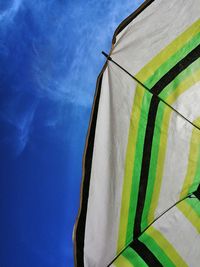 Low angle view of parasol against blue sky