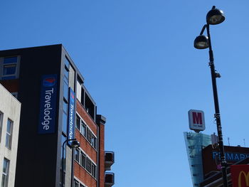 Low angle view of buildings against clear blue sky