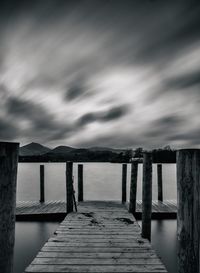 Wooden jetty on pier over sea against sky