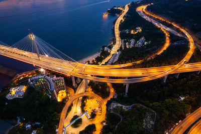 Aerial view of illuminated highway and bridge at night