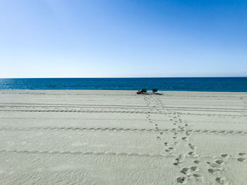 Scenic view of beach against clear blue sky