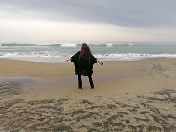 Rear view of man standing on beach