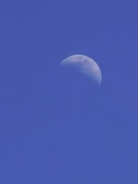 Low angle view of moon against blue sky