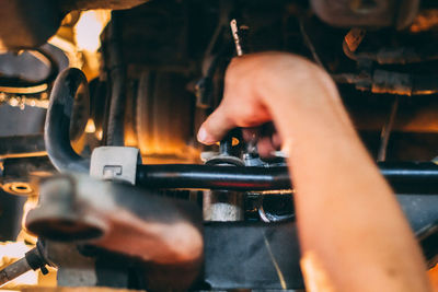 Cropped hand of man working on machine