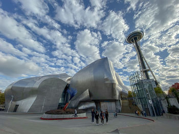 Low angle view of modern building against cloudy sky