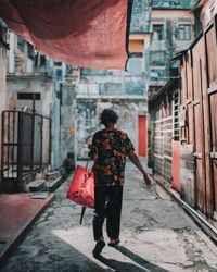 Rear view of woman walking on road