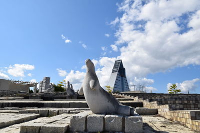 Low angle view of seagull on building against sky