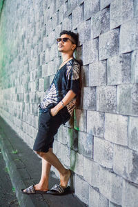 Young man standing against wall