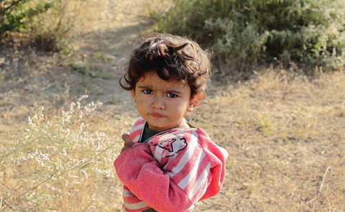 A small boy of indian origin looking at the camera angrily