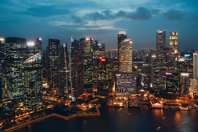 Illuminated buildings in city against sky at night