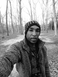 Portrait of mature man wearing warm clothing while standing in forest