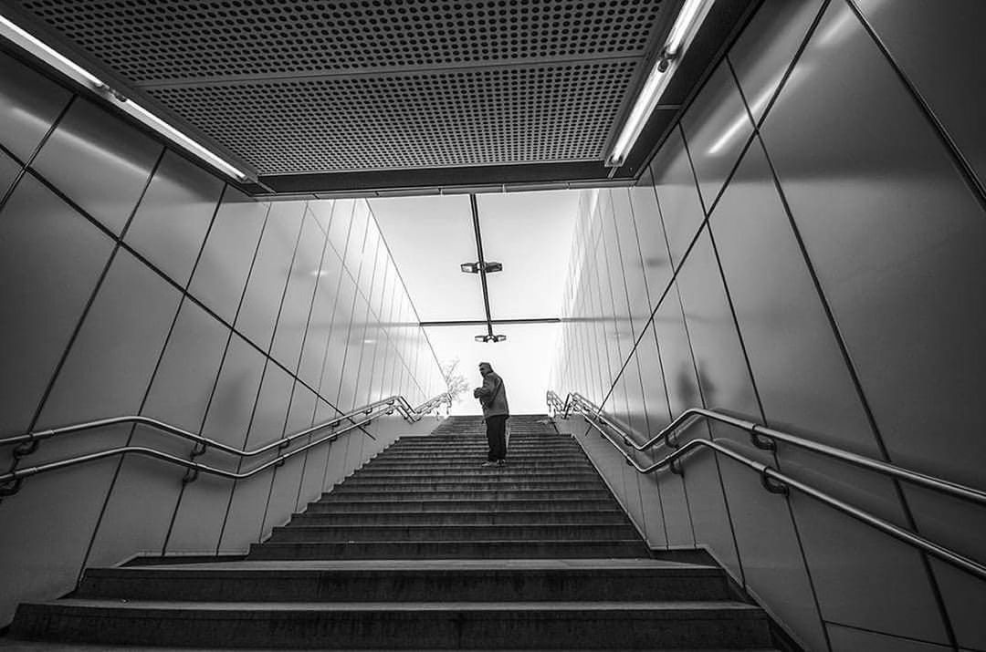 LOW ANGLE VIEW OF MAN ON STAIRCASE