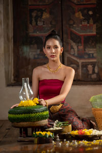 Portrait of young woman sitting with vegetables