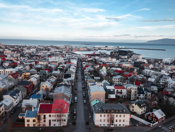 High angle view of townscape by sea against sky