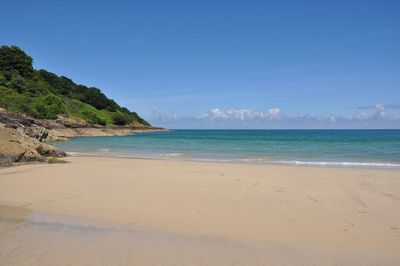 Scenic view of beach against clear blue sky