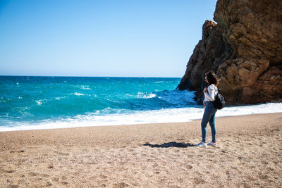 Full length of man on beach against clear sky