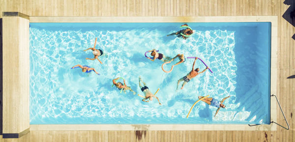 Top view of group of seniors doing water gymnastics in pool