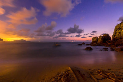 Scenic view of sea against dramatic sky during sunset