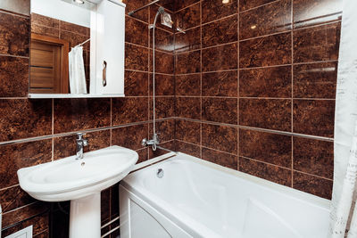 Stylish compact bathroom lined with brown tiles