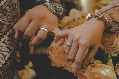 Midsection of couple hooking little finger during wedding ceremony