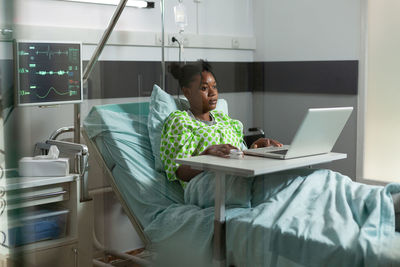 Man using mobile phone while sitting on bed