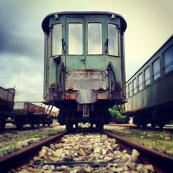 Old trains at shunting yard against sky