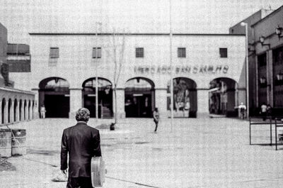 Rear view of man standing against building
