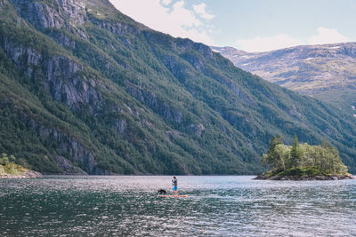 Scenic view of lake by mountains against sky