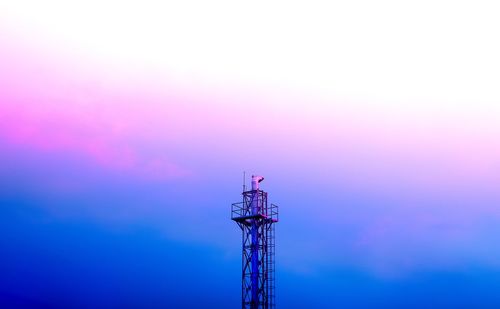 Low angle view of communications tower against sky during sunset