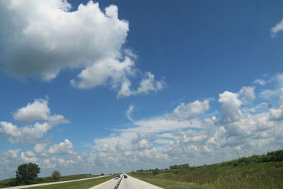 Country road against cloudy sky