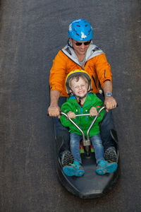 High angle view of father with son riding vehicle on road