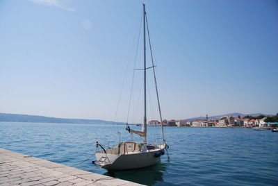 Sailboat sailing on sea against clear sky