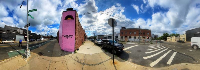 Panoramic view of city street against sky