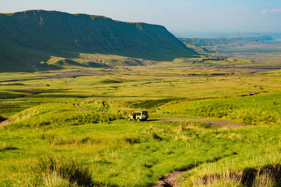 A safari vehicle against a mountain background at mount ol doinyo lengai in ngorongoro, tanzania