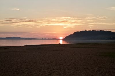 Scenic view of beach against sky during sunset