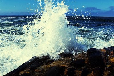 Close-up of waves splashing in sea against sky