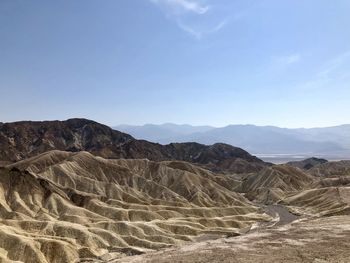 Scenic view of arid landscape against sky, zabriskie point