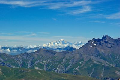 Scenic view of mountains against blue sky