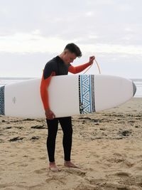 Full length of man standing on beach against sky