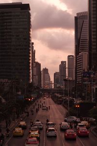 Traffic on city street by buildings against sky