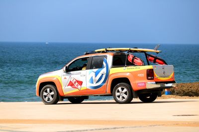 Vintage car by sea against clear sky